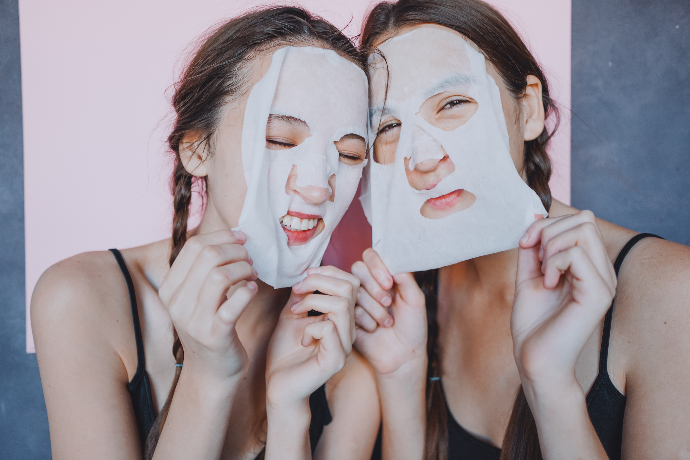 Young female twins with facial sheet masks